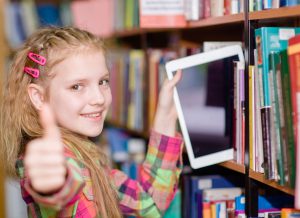 student with mobile device browsing bookshelves 